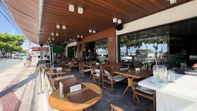 A varanda sob o toldo de madeira, com mesas de frente para a Avenida Atlântica